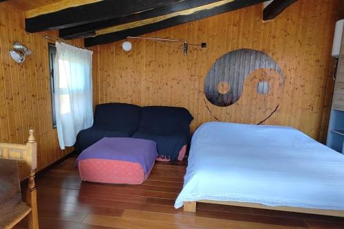 a bedroom with a bed and a couch in it at TAO casa WOOD apartamentos in Olot