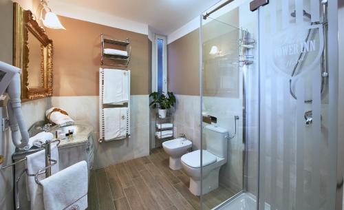 a bathroom with a toilet and a glass shower at Villa Tower Inn in Pisa