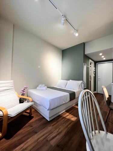 a bedroom with a large bed and a chair at 70 steps studio B in Thessaloniki