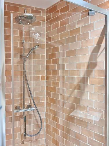 La salle de bains est pourvue d'une douche et d'un mur en briques. dans l'établissement Canal St Martin Miss Dodu, à Paris