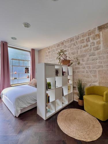 une chambre avec un lit blanc et une chaise jaune dans l'établissement Canal St Martin Miss Dodu, à Paris