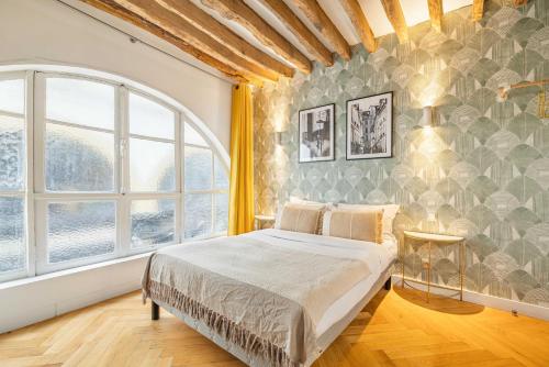 une chambre avec un lit et une grande fenêtre dans l'établissement Superb Historical Studio next to Louvre and Opera, à Paris