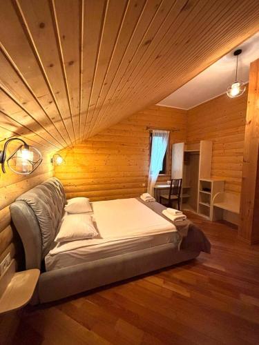 a large bed in a room with a wooden ceiling at Явір Резорт in Starychi