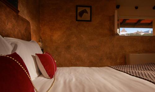 a bedroom with a bed with red and white pillows at Villa Tower Inn in Pisa