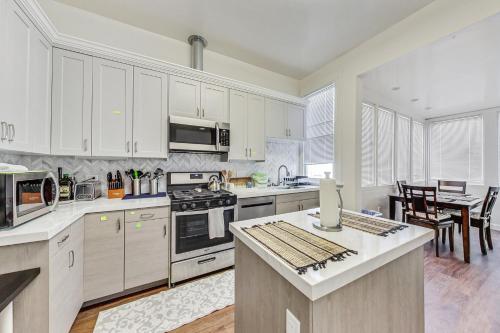 a large kitchen with white cabinets and a table at In the Heart of Haight Ashbury 5 Bedroom House in San Francisco