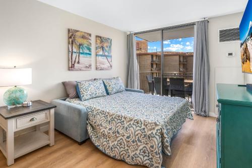 a bedroom with a bed and a couch and a table at Deluxe Oceanside Resort Vistas in Kihei