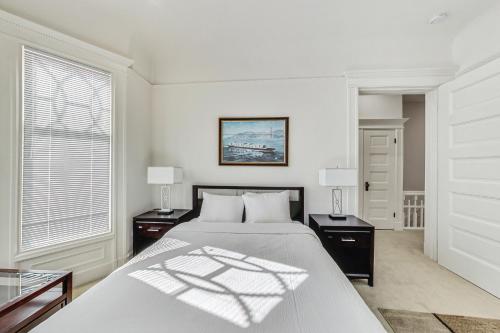 a white bedroom with a bed and two night stands at In The Heart Of Haight Ashbury 5 Bedroom House in San Francisco