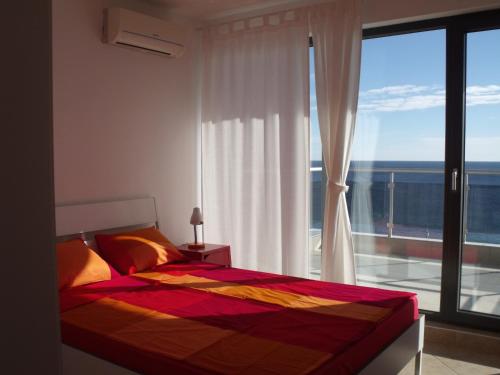a bedroom with a bed and a large window at The Beach House in Sozopol