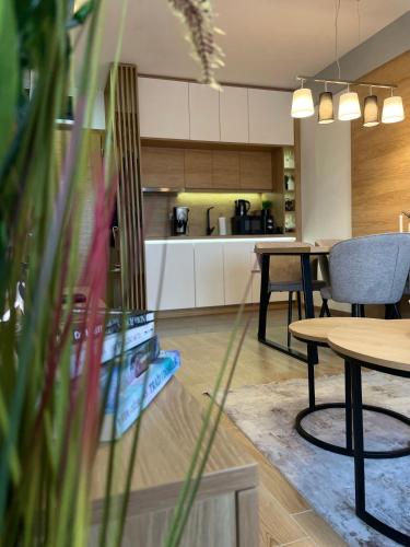 a living room with a table and a kitchen at Forest Zlatni Bor in Zlatibor