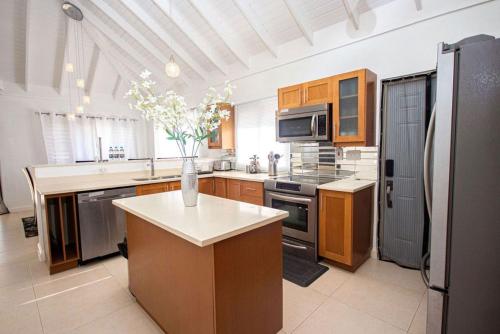 a kitchen with a vase of flowers on a counter at Luxury villas Oceanic View - Richmond Estate in Richmond