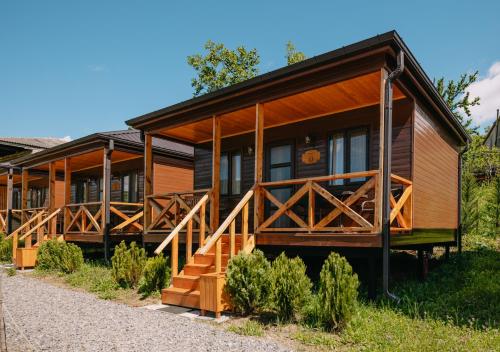 a log cabin with wooden railing and stairs in front at Chateau Ateni Cottages in Gori