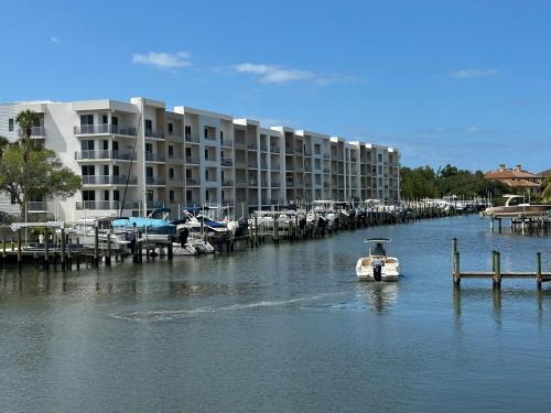 a small boat in the water next to a marina at Luxury 2 Bed 2 Bath Waterfront Condo with Patio Sunsets Gym and Parking in Sarasota