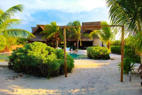 a resort with a swimming pool and a resort with palm trees at Lipsos Private Luxury Beachfront home in Progreso