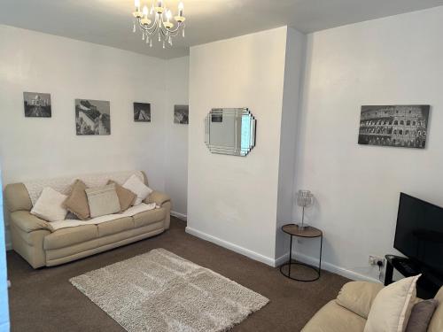 a living room with a couch and a television at Home and Away, close to Preston Park and Yarm High street in Stockton-on-Tees