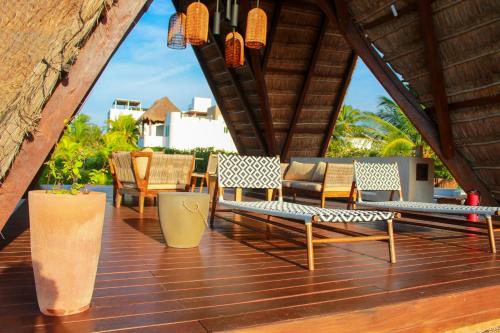 a patio with chairs and tables on a wooden deck at Lipsos Private Luxury Beachfront home in Progreso