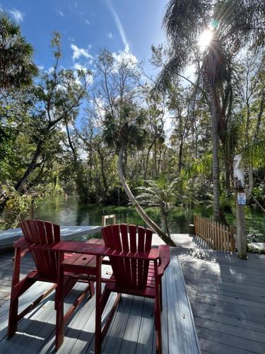 a wooden table and two chairs on a deck at Main River Retreat hot tub, canoe with trolling motor in Spring Hill