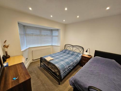 a bedroom with a bed and a window at Monyhull Homestay - near City centre Kingsheath NIA NEC BHX in Birmingham