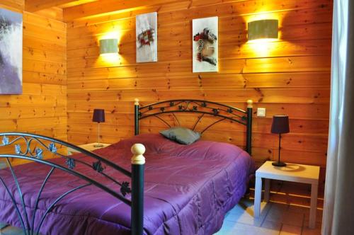une chambre avec un lit dans un mur en bois dans l'établissement Chalet Modus, Belle vue lac, Sauna, Wifi, à Gérardmer