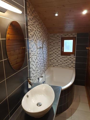une salle de bain avec un lavabo blanc et une baignoire dans l'établissement Chalet Modus, Belle vue lac, Sauna, Wifi, à Gérardmer