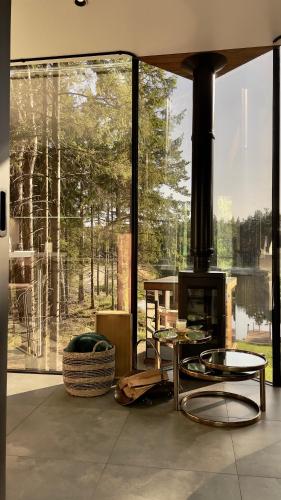 a living room with a fireplace and a large window at Roostajärve Minivilla in Elbiku