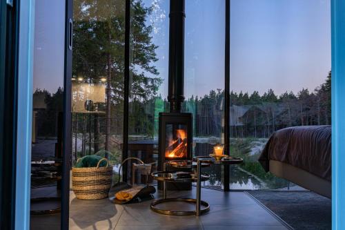 a fireplace in a room with a large window at Roostajärve Minivilla in Elbiku