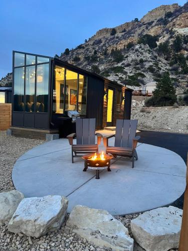 a house with two chairs and a table and a fire at Valley View in Orderville