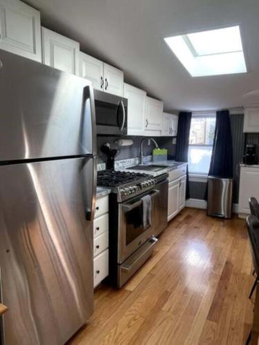a kitchen with a stainless steel refrigerator and white cabinets at DC Studio Near Capitol & Metro - Parking Included in Washington, D.C.