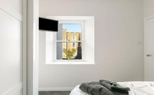 a bedroom with a window and a stuffed animal on a bed at Castle Street Apartments - Luxury Ettrick Apartment in Rothesay