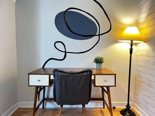 een bureau met een stoel en een spiegel aan de muur bij Stylish 1-BDRM Prime Location, Unit 2 in Halifax