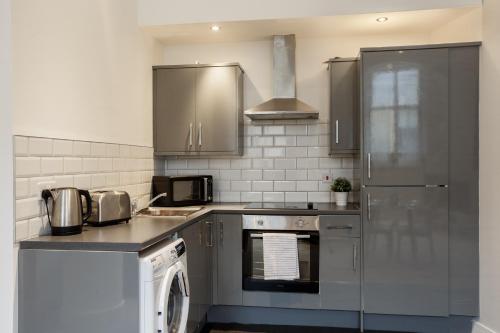 a kitchen with stainless steel appliances and a dishwasher at City Centric 1BR Apartment in Bradford