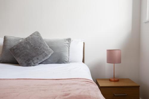 a bed with a pillow and a lamp on a night stand at City Centric 1BR Apartment in Bradford