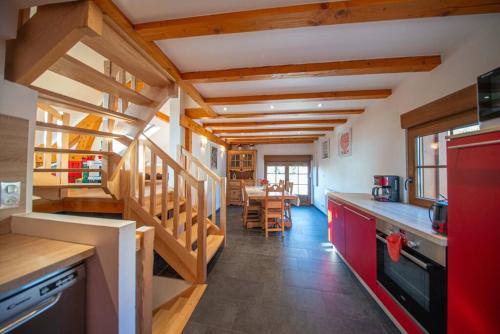 Il comprend une cuisine dotée de plafonds en bois et d'un réfrigérateur rouge. dans l'établissement Le chalet Montanea-Jacuzzi-Free parking, à Ventron