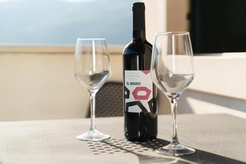 a bottle of wine and two wine glasses on a table at La Pietra Nera in San Giovanni Ilarione