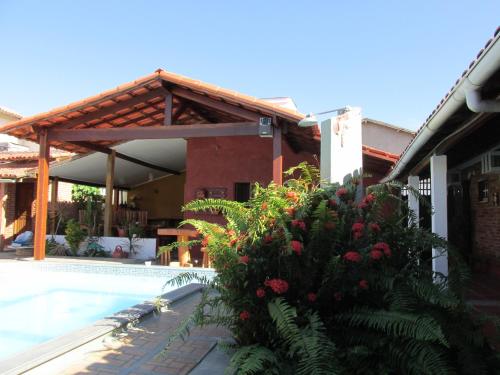 a house with a swimming pool in front of a house at Pousada Askalon in Itaúnas
