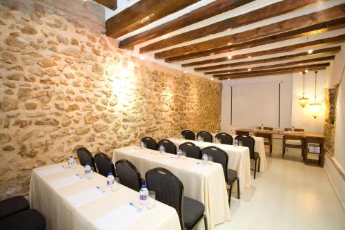 a room with tables and chairs and a stone wall at La Posada del Mar in Denia