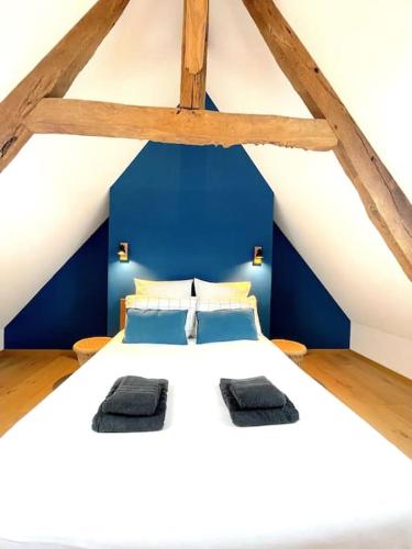 a bedroom with a large white bed with blue walls at Charmante Maison Rustique in Piriac-sur-Mer