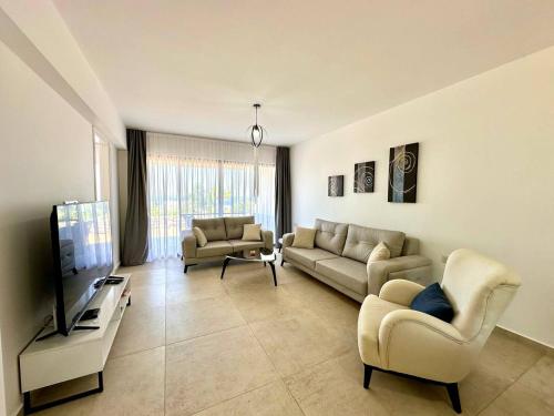 a living room with two couches and a tv at Retreat site, block A1, unit 1 in Küçükerenköy