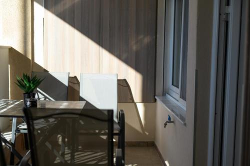 a table and chairs in a room with a window at Neria 1 in Alexandroupoli