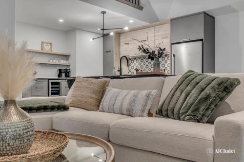 ein Wohnzimmer mit Couch und Küche in der Unterkunft Artémis - Paisible et Familial - Spa privé in Sainte-Catherine