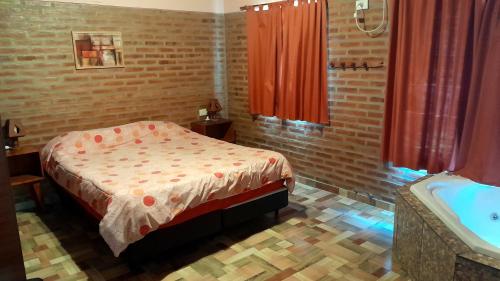 a bedroom with a bed and a bath tub at Luz Alba Cabañas in Mina Clavero