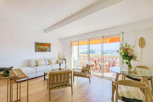 un salon avec un canapé blanc et une table dans l'établissement LE VOILIER avec terrasse panoramique vue mer et port, proche du Palais, Croisette et plages, à Cannes