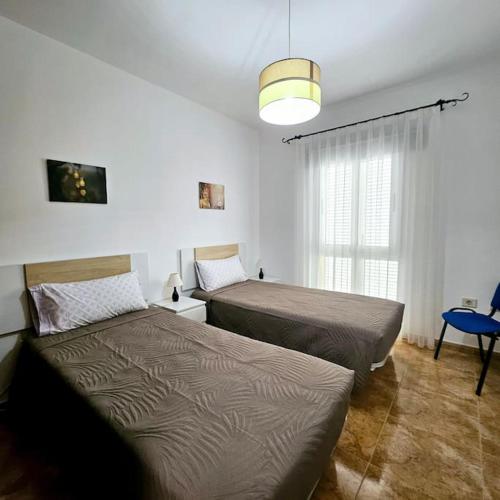 a bedroom with two beds and a window at Casa Criso Puerto del Rosario in Puerto del Rosario