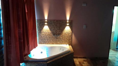 a bathroom with a tub with lights on the wall at Luz Alba Cabañas in Mina Clavero