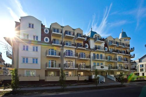 a large building with the sun behind it at Regina Maris by Baltic Home in Świnoujście