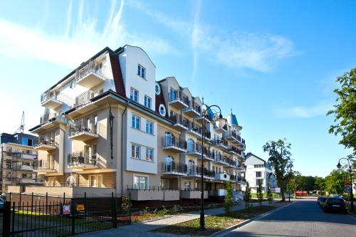 ein weißes Gebäude mit Balkon auf einer Straße in der Unterkunft Regina Maris by Baltic Home in Świnoujście