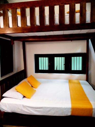 a bedroom with two bunk beds with yellow pillows at Riverston Nature Villa in Rattota