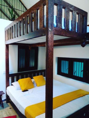 a bedroom with two bunk beds with yellow pillows at Riverston Nature Villa in Rattota