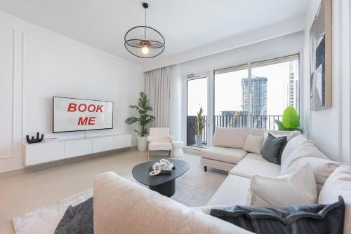 a living room with a couch and a tv at Free housekeeping visits during your stay - StayShort - Captivating 1BR apartment in Dubai Creek Harbour in Dubai