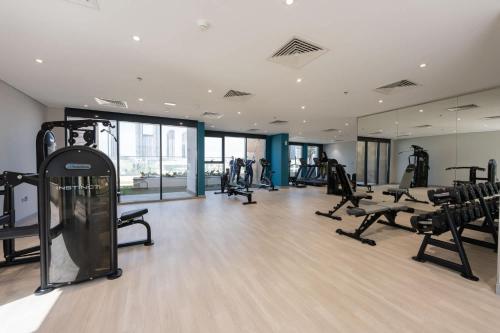 a gym with treadmills and ellipticals in a building at Free housekeeping visits during your stay - StayShort - Modern 1-Bedroom Apartment at Azizi Riviera in Meydan in Dubai