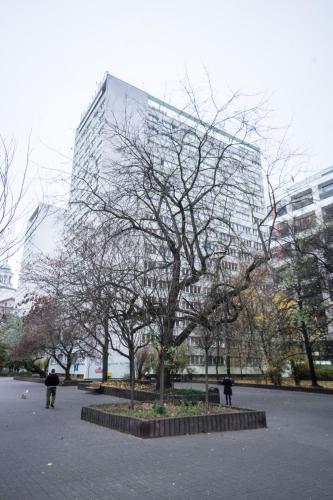 a tree in front of a tall building at Old Town Heart XIX Bagno - Central in Warsaw